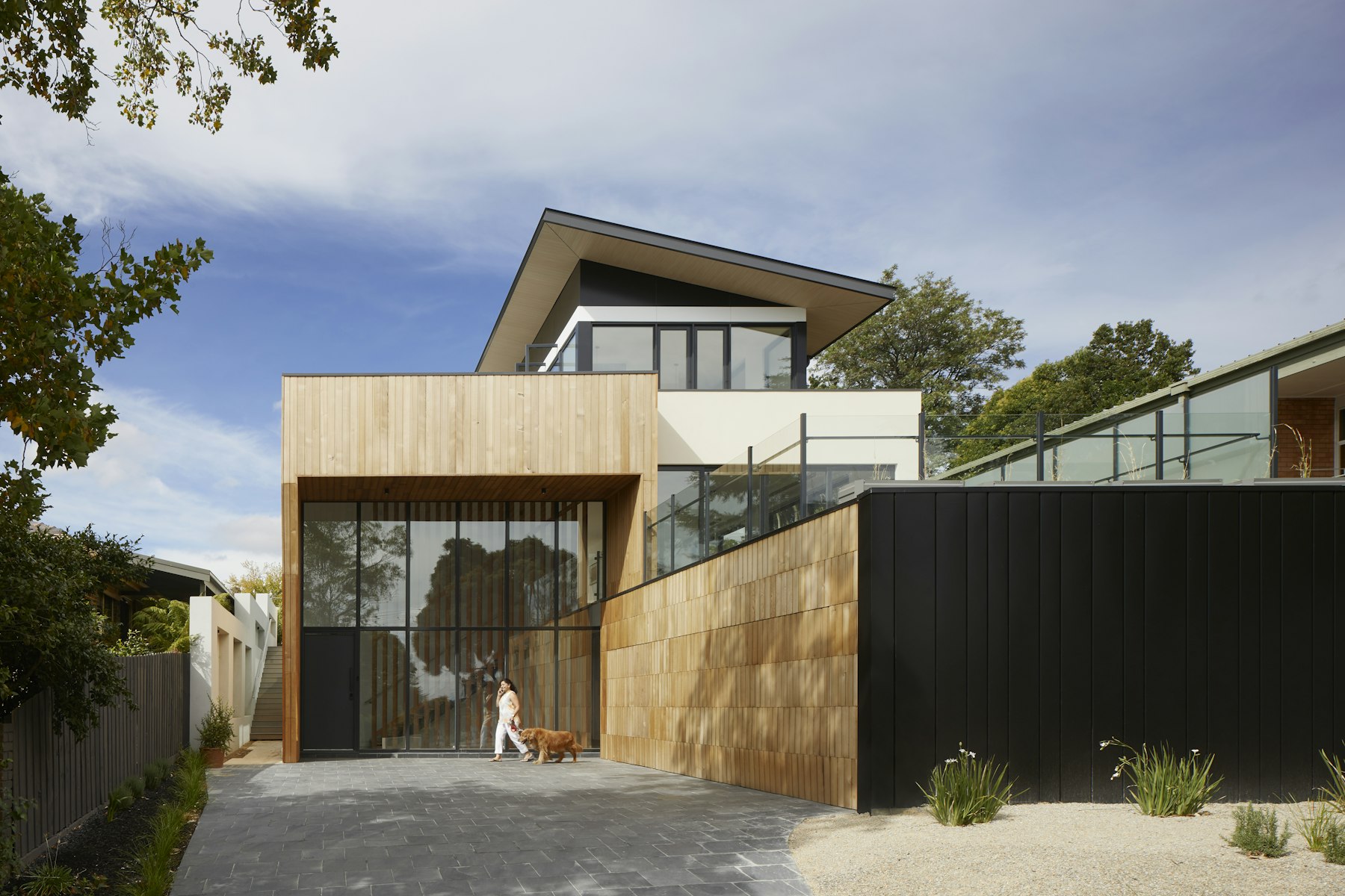 Modern luxury villa with warm timber cladding, captured in soft evening light